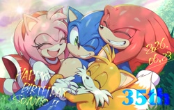 Size: 2048x1293 | Tagged: safe, artist:kot618, amy rose, knuckles the echidna, miles "tails" prower, sonic the hedgehog, 2026, birthday, clouds, daytime, english text, eyes closed, grass, grin, group, group hug, happy, happy birthday, hugging, looking at viewer, lying down, mouth open, open smile, outdoors, quartet, smile, smiling at viewer, sun, text, wink, winking at viewer